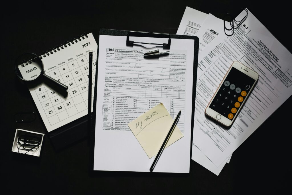 High angle view of tax forms, calculator, calendar, and pen for financial planning.